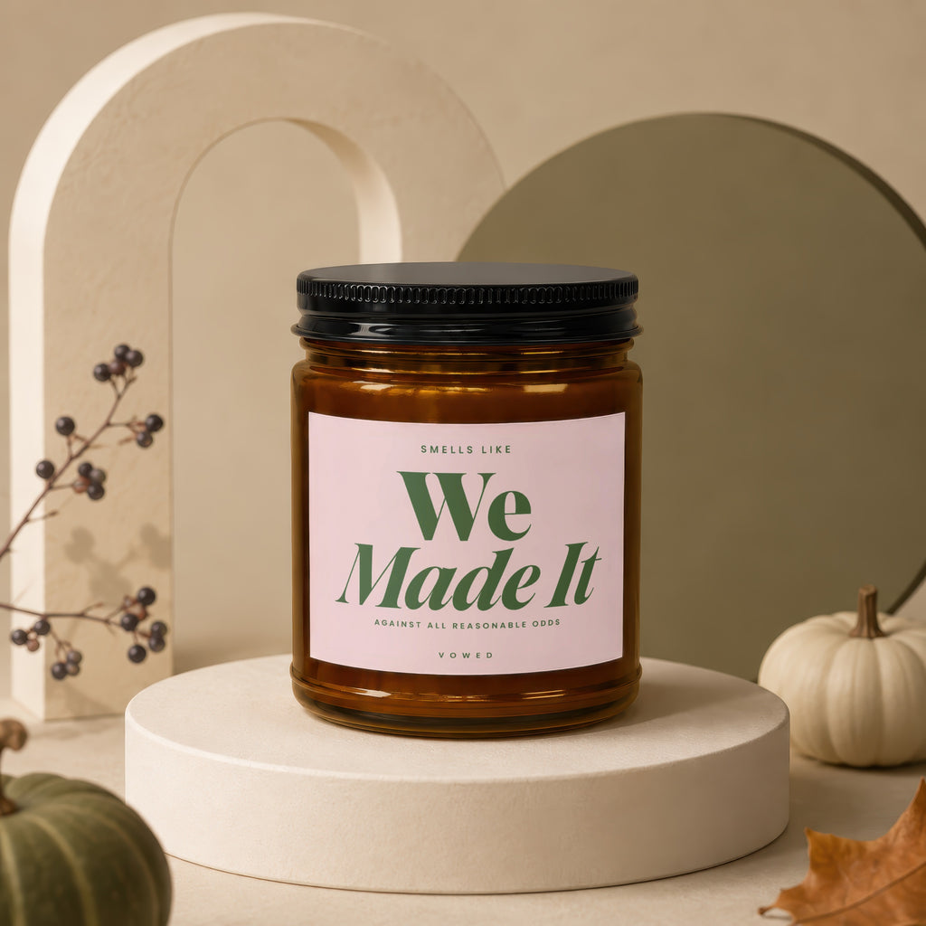 Amber jar candle with a pink label saying "We Made It."