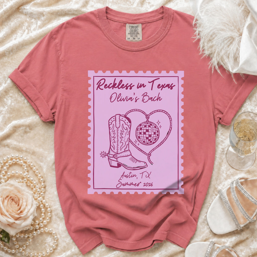 Pink graphic tee with "Reckless in Texas Olivia's Bach Austin, TX Summer 2026".
