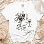 White t-shirt with sketch of roses, candle, martini glass, clutch, and text "MOB" and "Mother of the Bride No Tricks, Just Trauma."
