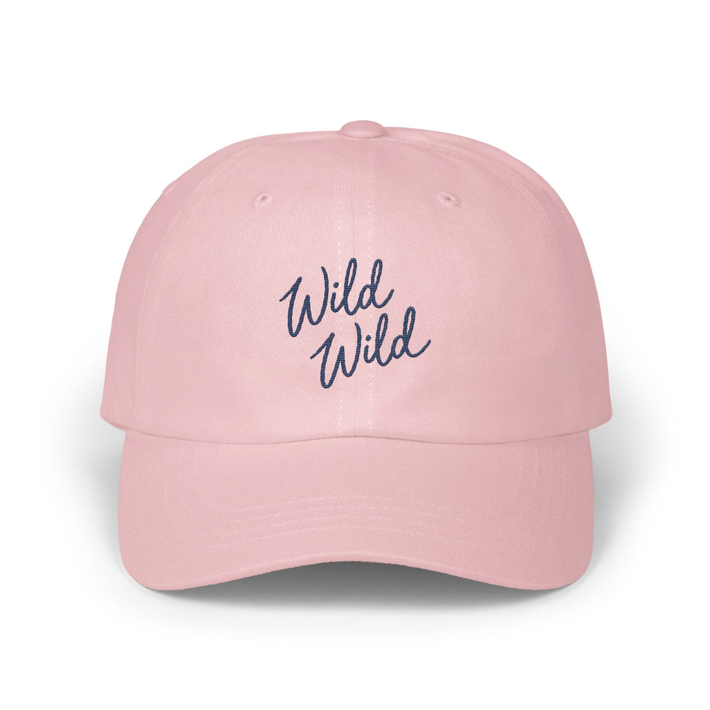 A light pink baseball cap features embroidered blue text reading Wild Wild on the front.