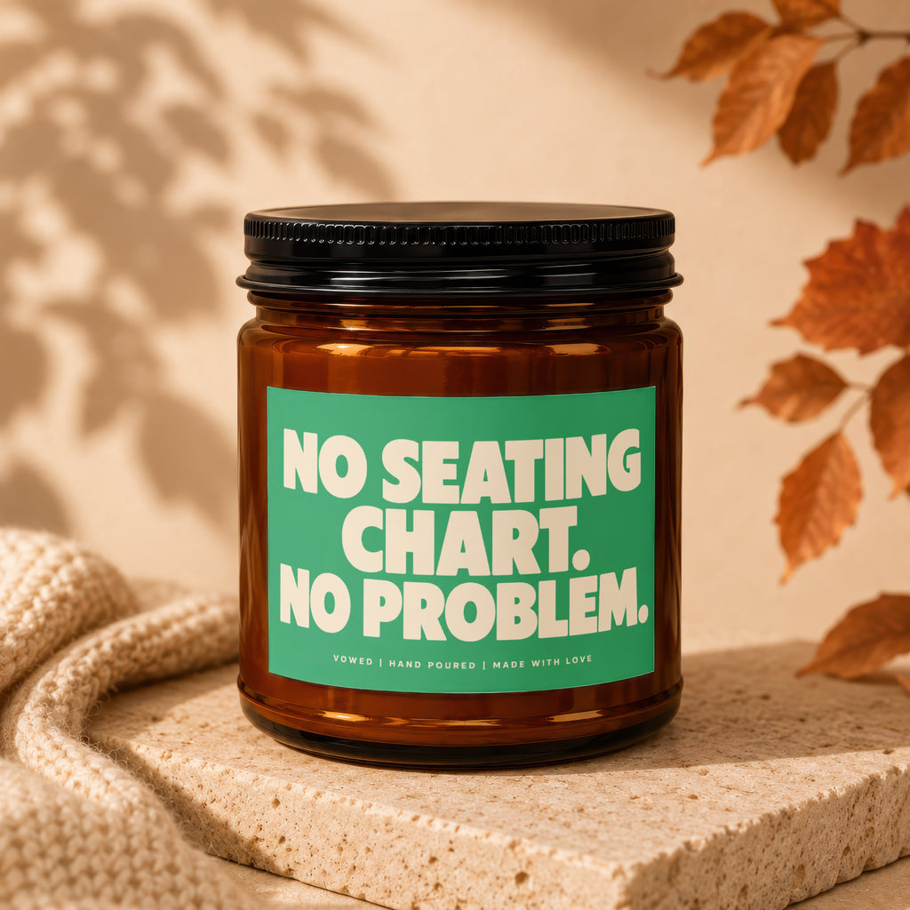 Amber jar candle with "No seating chart. No problem." text on green label.