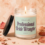 Candle with lit wick and lid beside it, reads "Smells Like Professional Bride Wrangler".