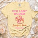 Pink watercolor cowboy hat graphic on a yellow t-shirt with event details.