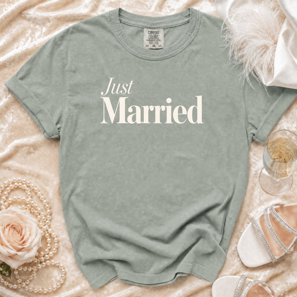 Grey "Just Married" t-shirt on a velvet background with wedding accessories.
