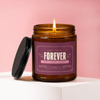 Amber jar candle with lit flame, reads "Forever One Love Story".
