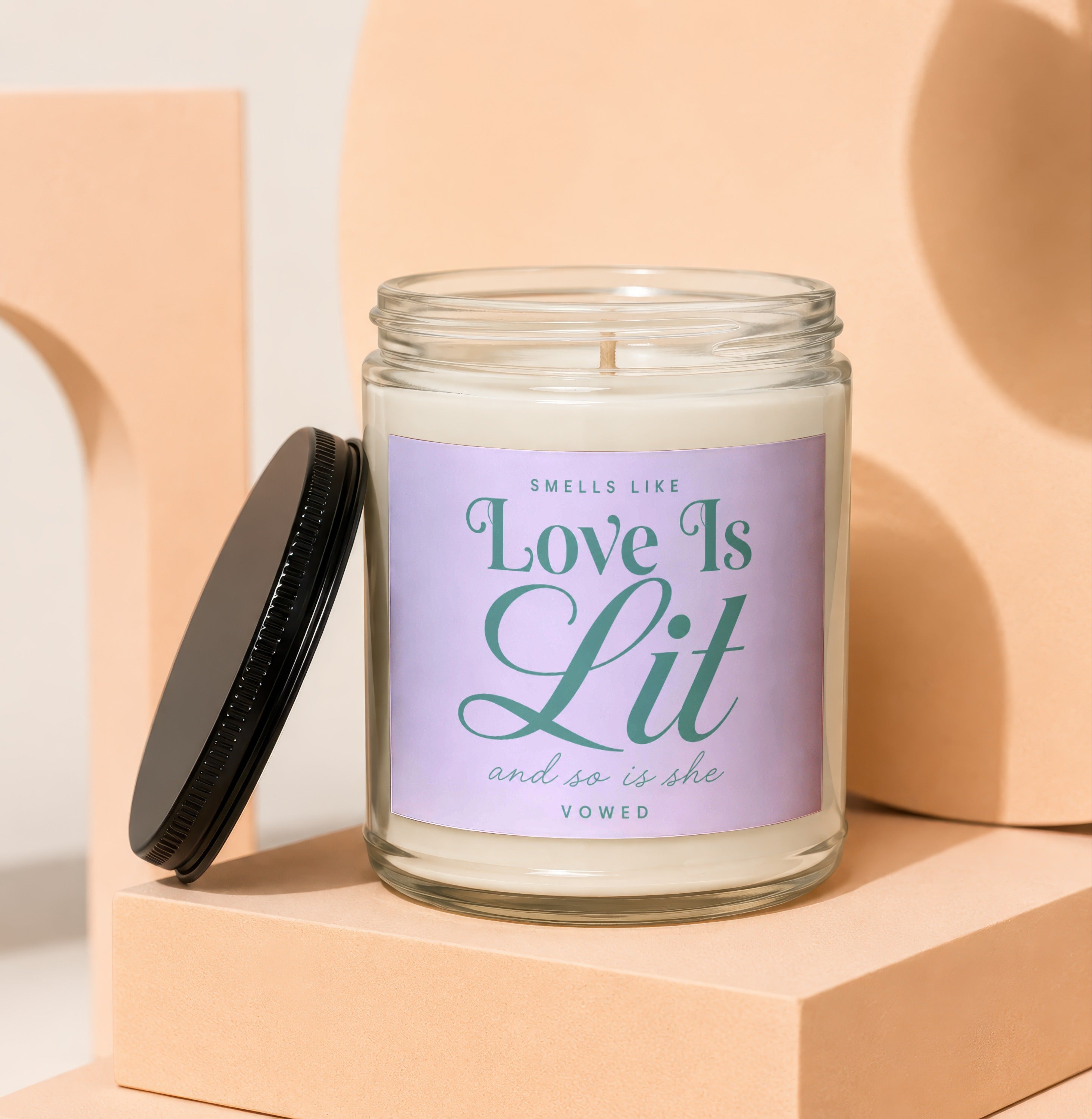 Candle with "Smells Like Love Is Lit" text on a lavender label.