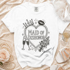 White t-shirt with "Maid of Dishonor" text, crowns, lips, roses, and champagne glasses.