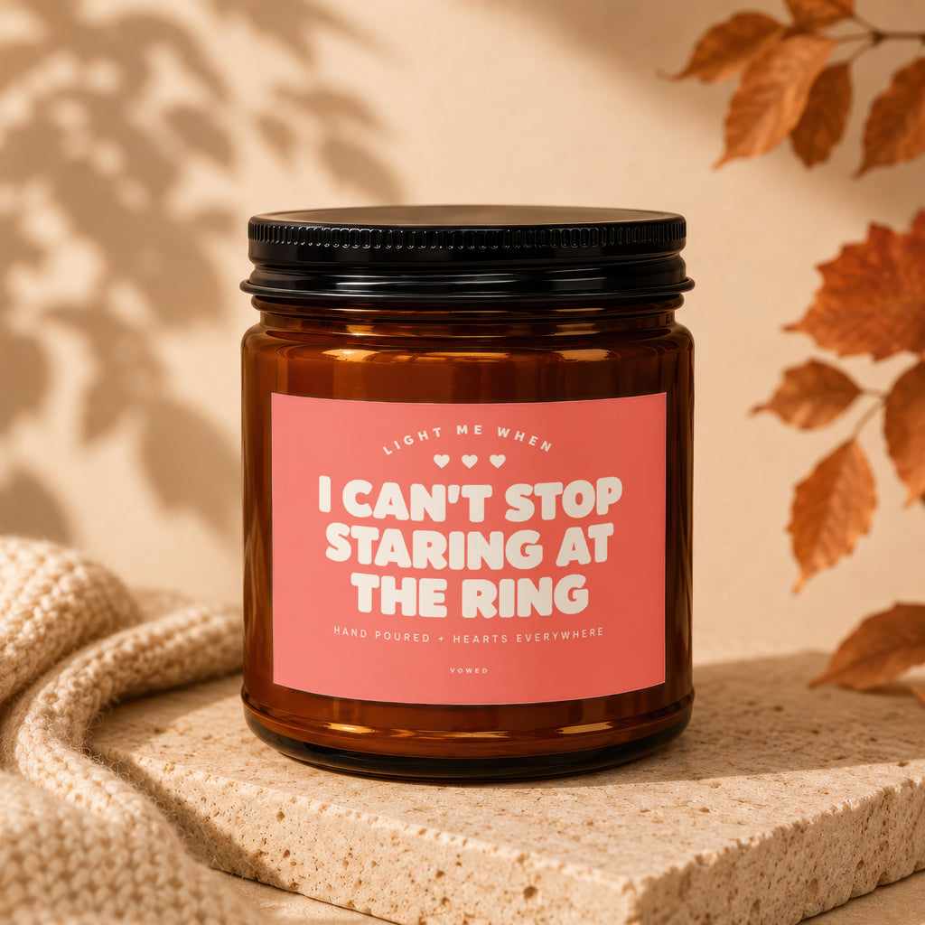 Amber jar candle with pink label reading "I Can't Stop Staring At The Ring".
