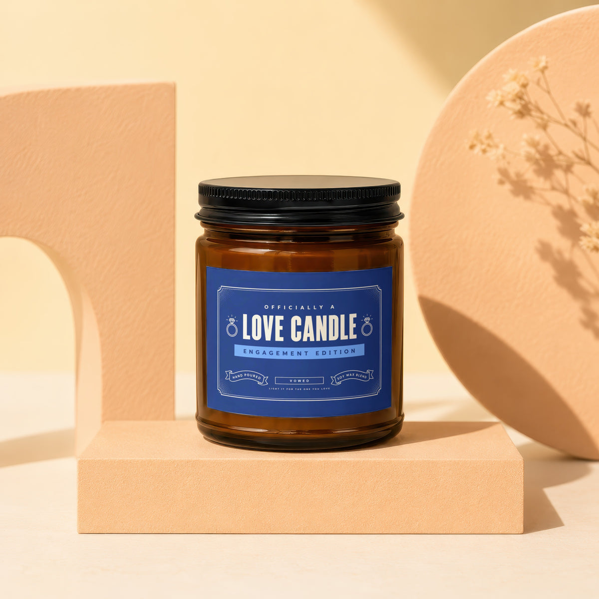 Brown glass candle with dark lid labeled "Love Candle Engagement Edition".