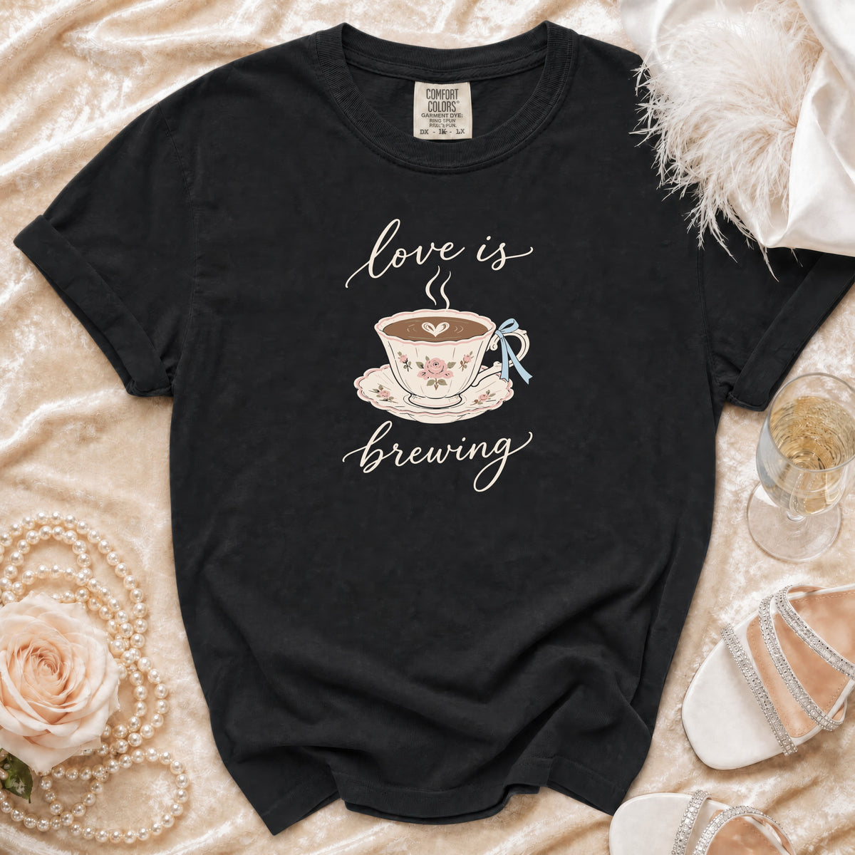 Black t-shirt with "love is brewing" text and a teacup graphic.