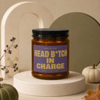Amber candle with purple label reading "Smells Like Head B*tch In Charge".
