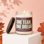 Glass candle with lit wick and "ROSTER: ONE TEAM, ONE DREAM" text.