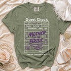 Green t-shirt with "Guest Check Mother of the Bride Surviving Halloween & Her Daughter's Wedding" graphic.
