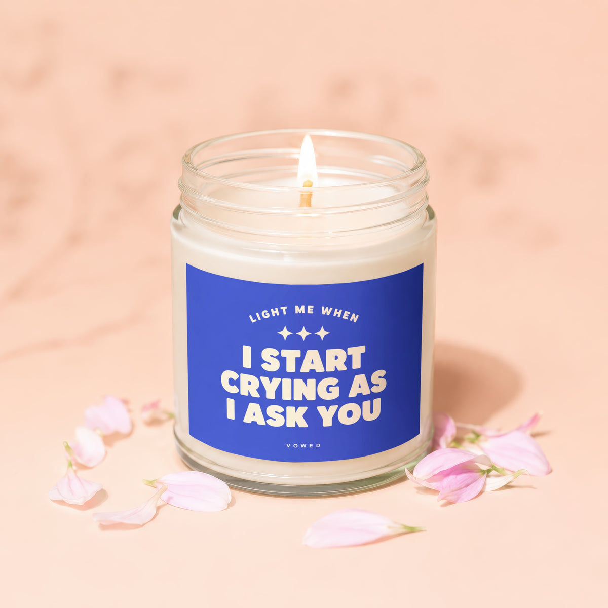 Candle with blue label reading "Light me when I start crying as I ask you."
