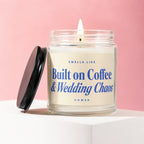 Glass jar candle with a lit wick, displaying "Smells Like Built on Coffee & Wedding Chaos" text.