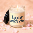Jar candle with lit flame, "In my bride era." text, and VOWED logo.