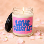Candle with a lit wick and a pink label reading "LOVE, FULLY LIT".