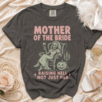Gray t-shirt with "MOTHER OF THE BRIDE RAISING HELL NOT JUST HER" graphic.