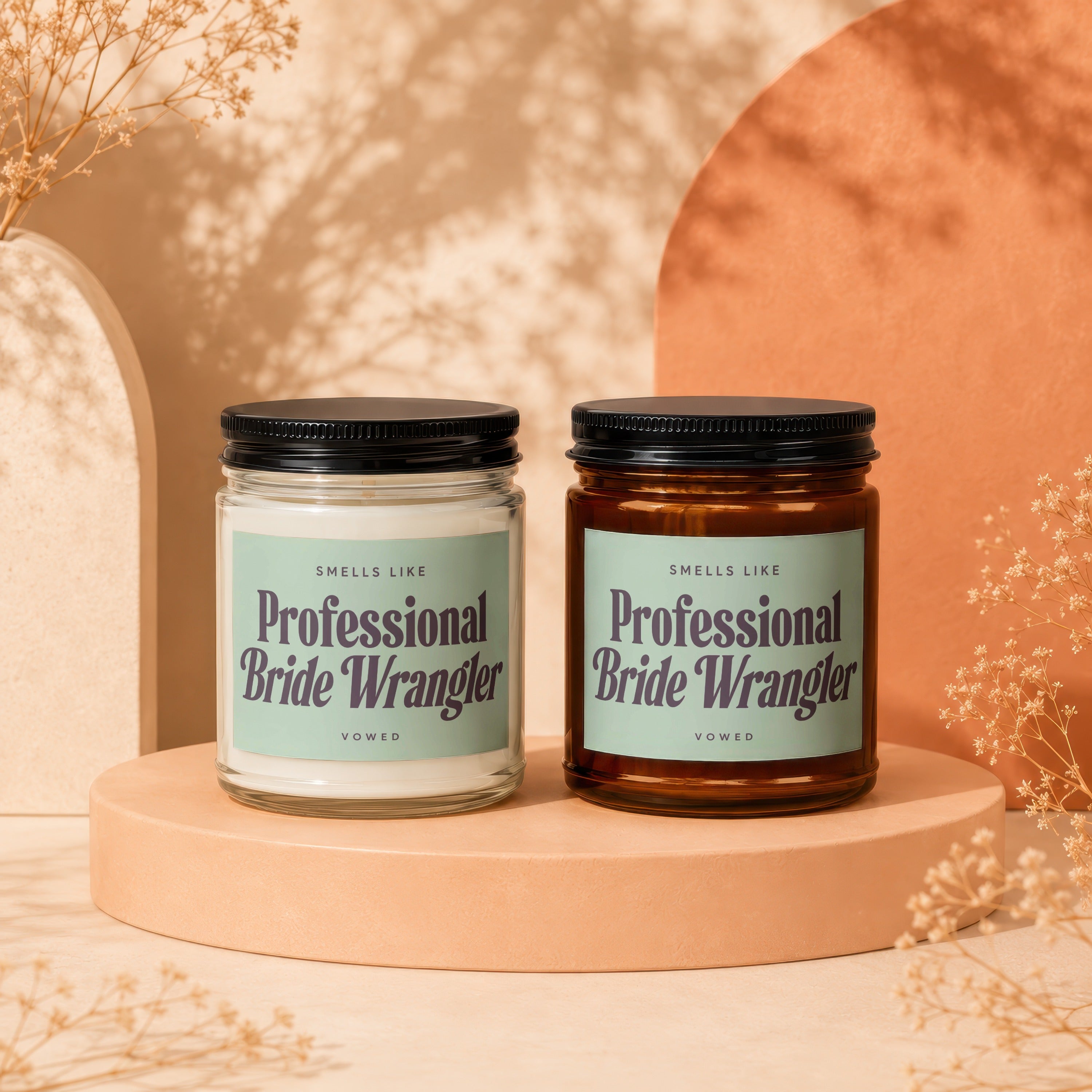 Two candles with "Professional Bride Wrangler" labels sit on a peach pedestal.