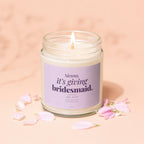 Candle with purple label saying "Sienna, it's giving bridesmaid. say yes?"
