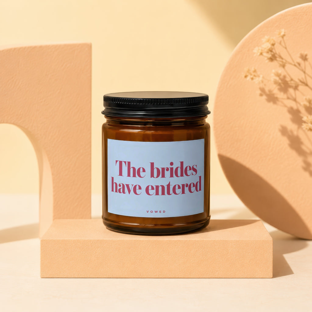 Amber candle with light blue label reading "The brides have entered", VOWED.