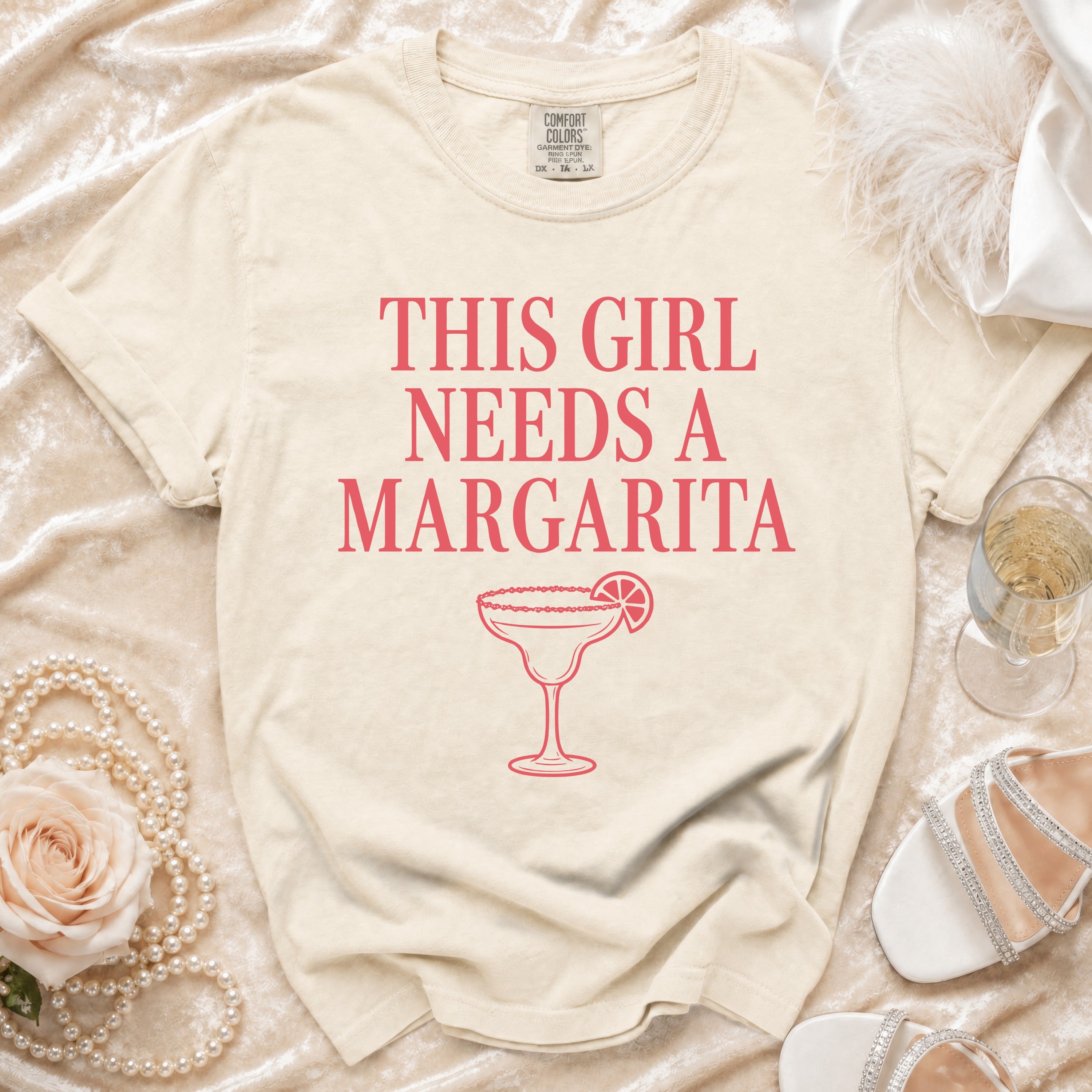 Cream t-shirt with "This Girl Needs A Margarita" text and margarita graphic.