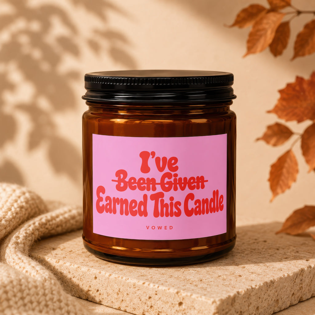 Amber candle with "I've Been Given Earned This Candle VOWED" text on a pink label.