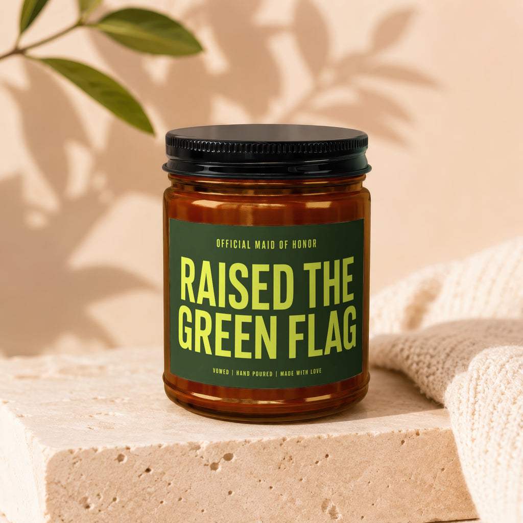 Candle with "Raised the Green Flag Official Maid of Honor" text on a dark green label.
