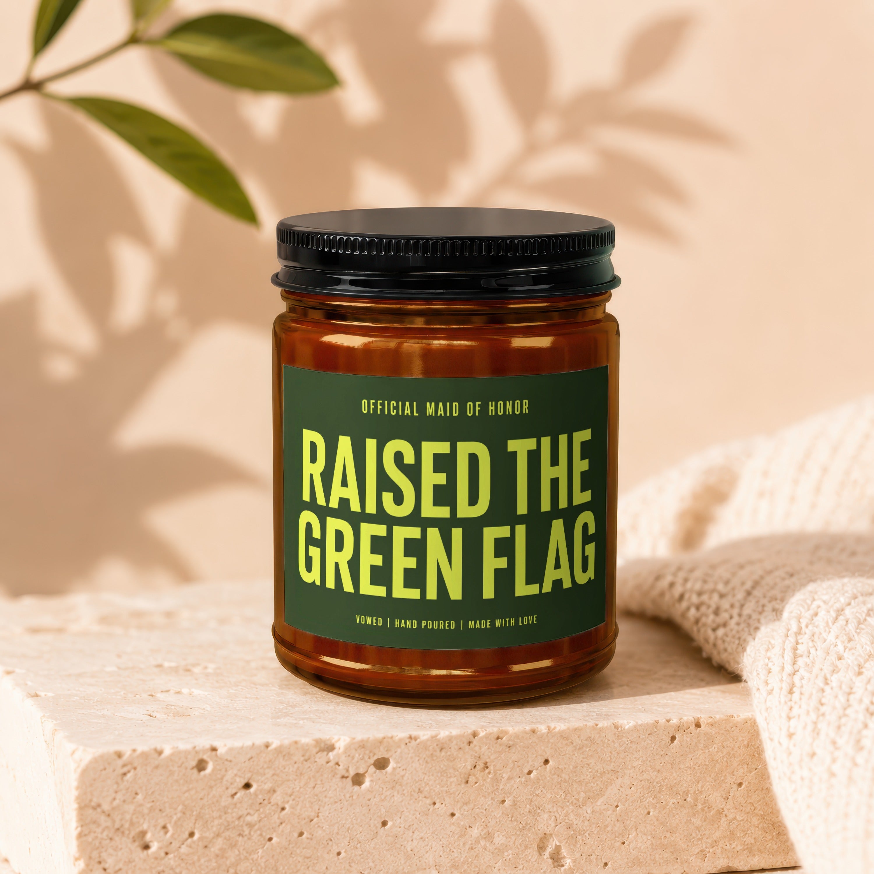 Candle with "Raised the Green Flag Official Maid of Honor" text on a dark green label.