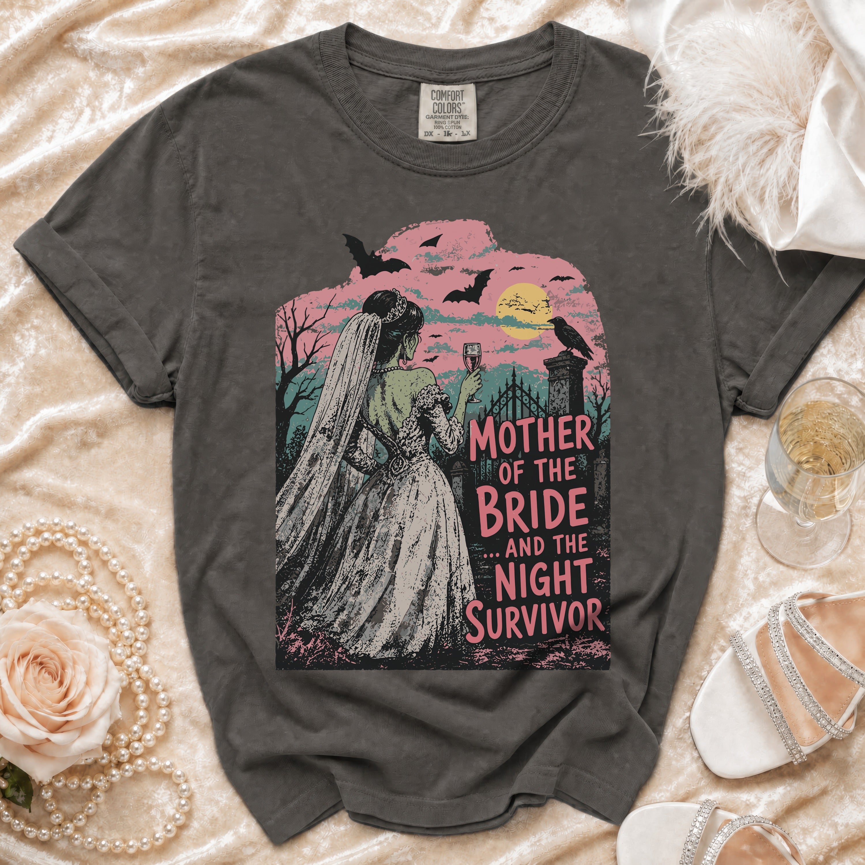 Dark gray t-shirt featuring a green zombie bride in a veil holding a glass, with text reading MOTHER OF THE BRIDE AND THE NIGHT SURVIVOR.