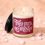 Candle with lit wick and "Two Mrs, no mister VOWED" text on label.