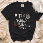 Black t-shirt with "This Bride Bites" graphic featuring vampire fangs and wedding elements.