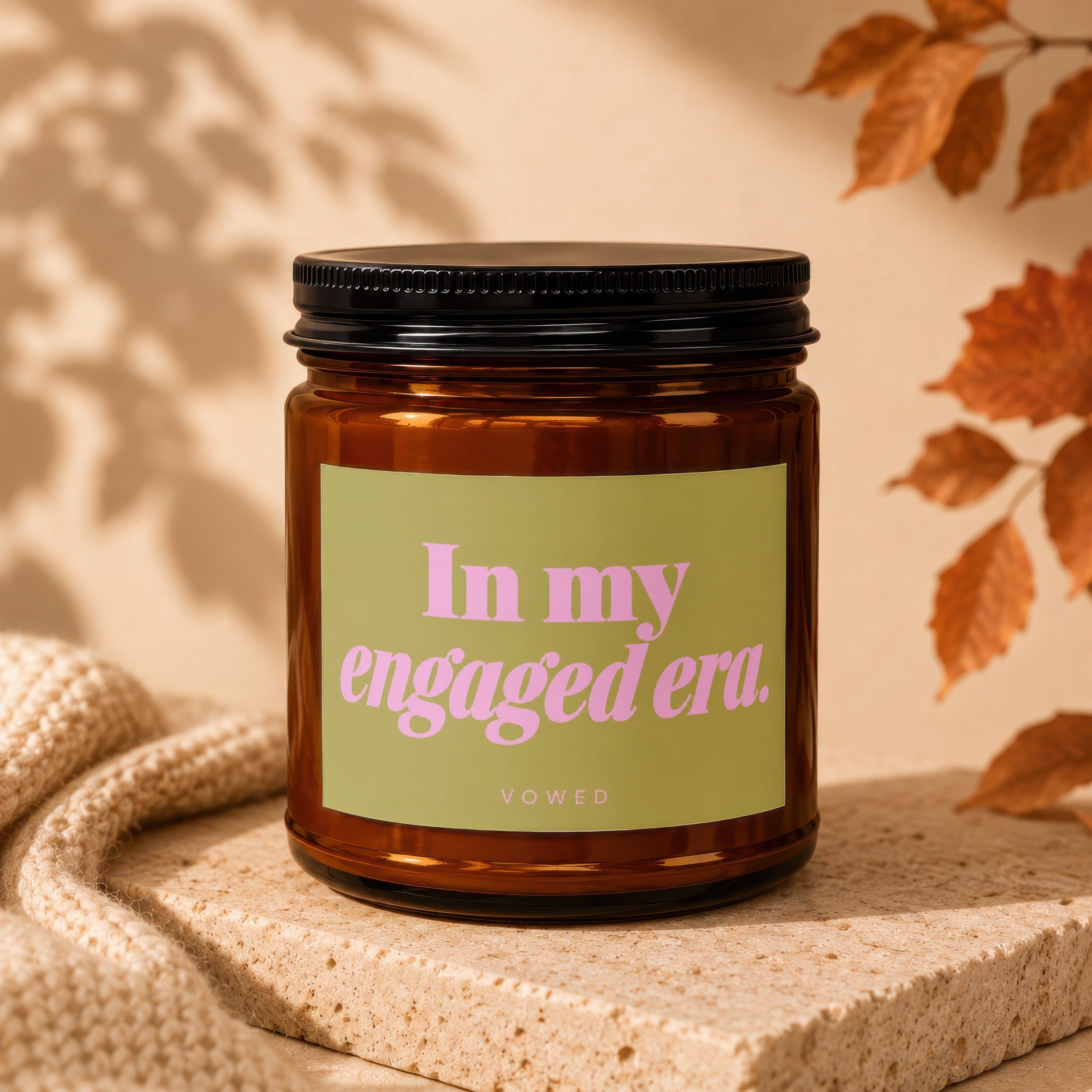Amber jar candle with a light green label reading "In my engaged era."