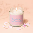Candle with "So glad you found each other" text on a pink label, surrounded by petals.