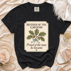 Black t-shirt with "Mother of the Groom Proud of the man he became" graphic.