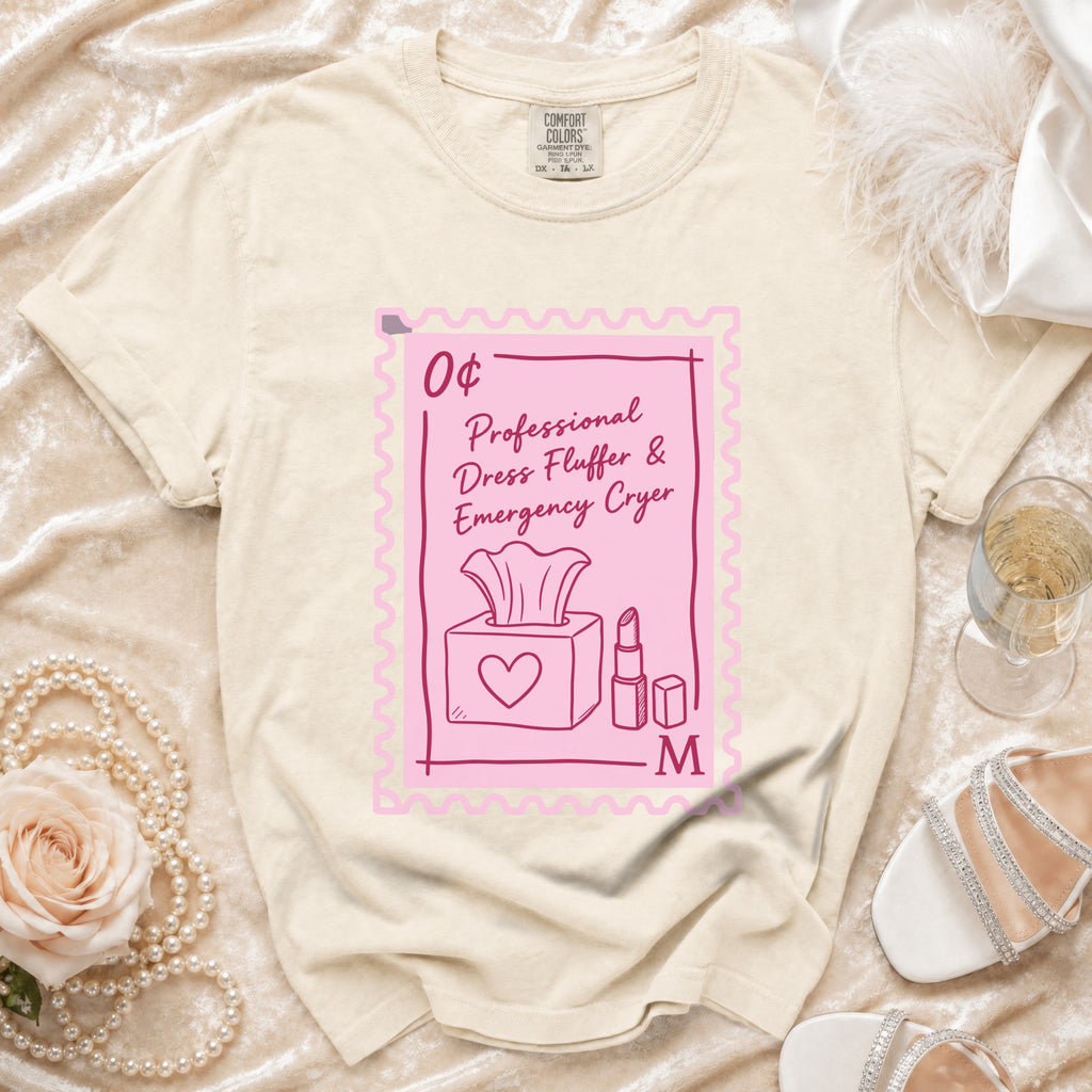 Cream t-shirt with a pink stamp graphic that says "Professional Dress Fluffer & Emergency Cryer".