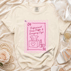 Cream t-shirt with a pink stamp graphic that says "Professional Dress Fluffer & Emergency Cryer".