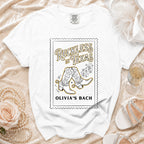 White t-shirt with "Reckless in Texas" and cowboy boots graphic.