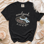 Black t-shirt with "newlywed & out of office" graphic, hat, sunglasses, and rings.