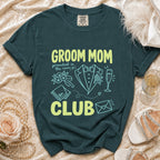 Dark teal t-shirt with "Groom Mom Club" text and wedding icons.