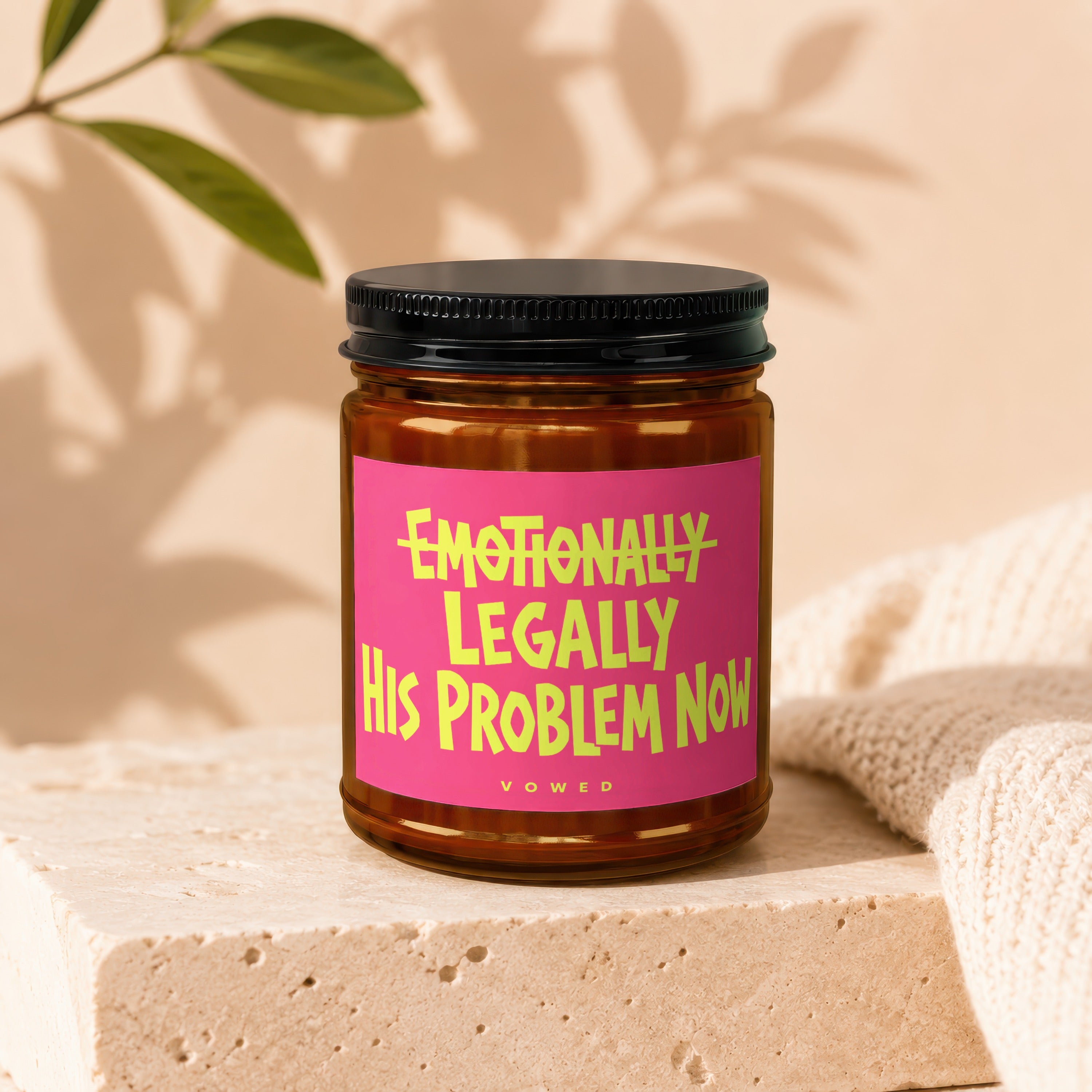 Candle with text "Emotionally Legally His Problem Now Vowed" on a pink label.