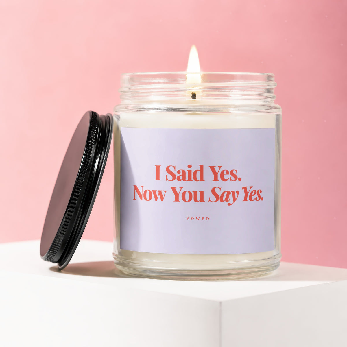 Lit candle in a glass jar with lid off, label reads "I Said Yes. Now You Say Yes."