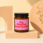 Brown glass candle with pink label reading "I've Been Given Earned This Candle".