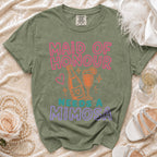 Olive green t-shirt with "Maid of Honour Needs a Mimosa" text and drink graphic.