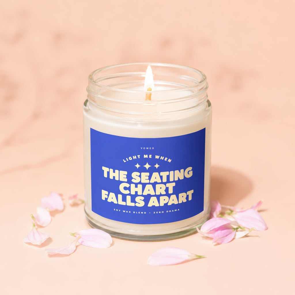 Candle with blue label reading "Light me when the seating chart falls apart".