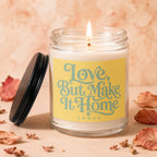 Jar candle with lit flame on yellow label reading "Love, But Make It Home VOWED."