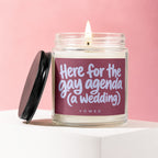 Jar candle with lit wick and label reading "Here for the gay agenda (a wedding)".