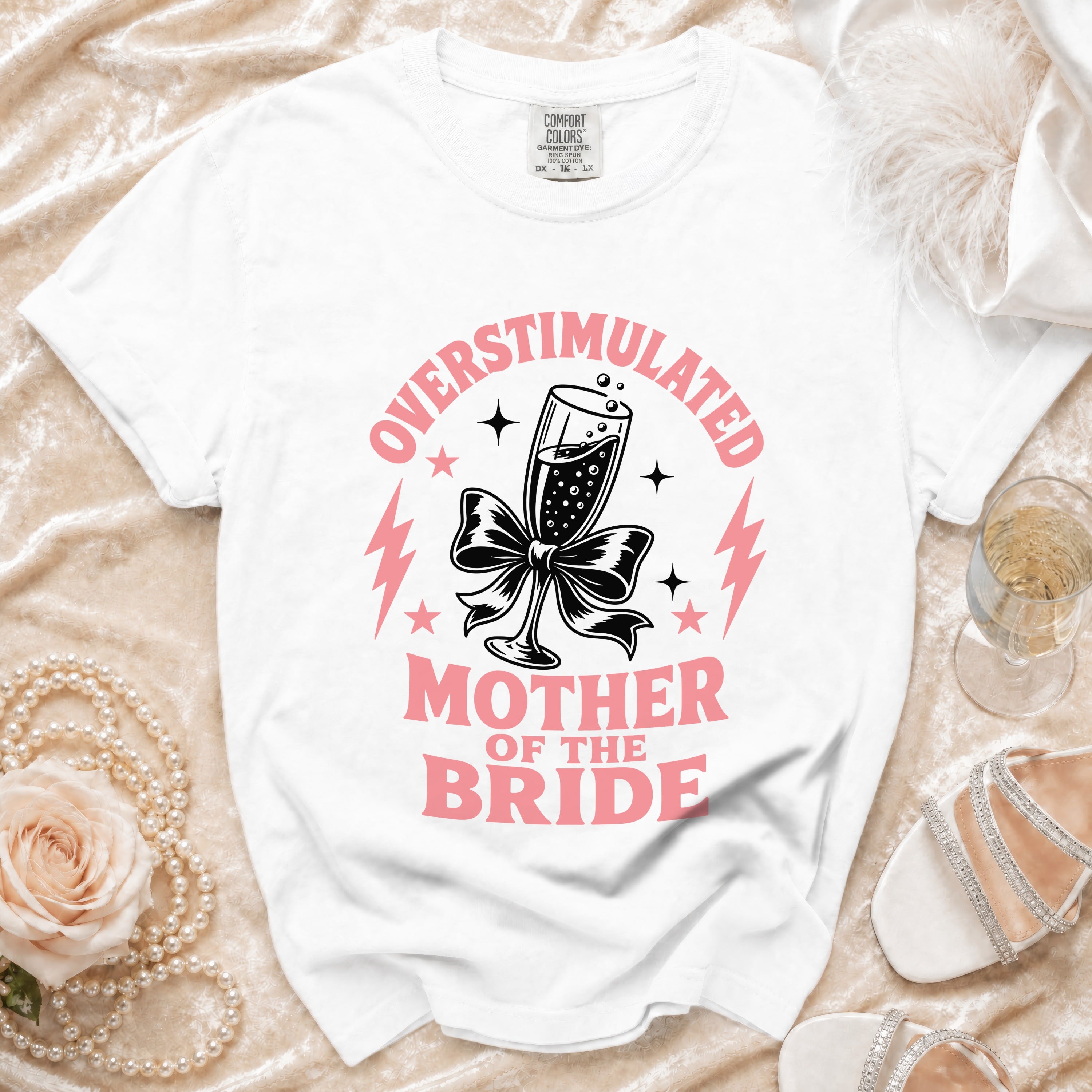 White t-shirt with "Overstimulated Mother of the Bride" text and champagne glass graphic.