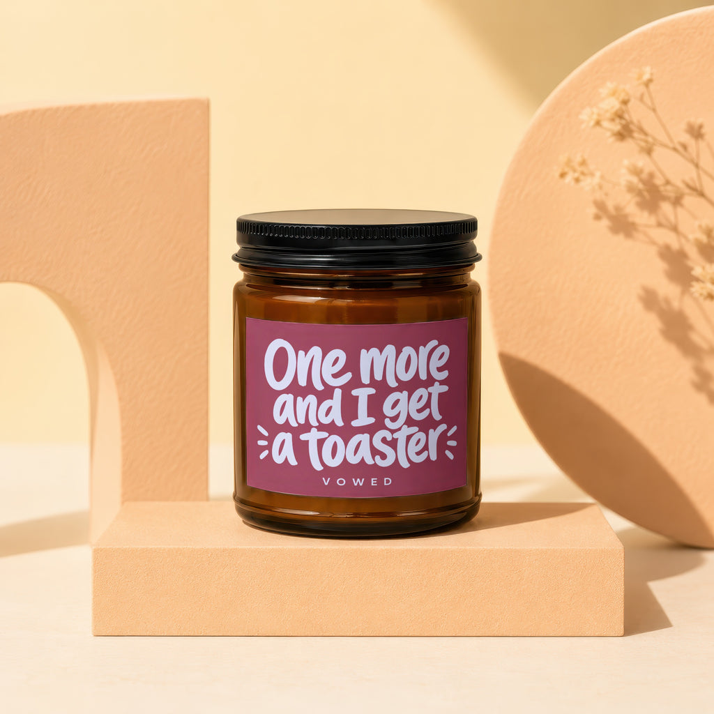 Brown glass candle with a maroon label reading "One more and I get a toaster"