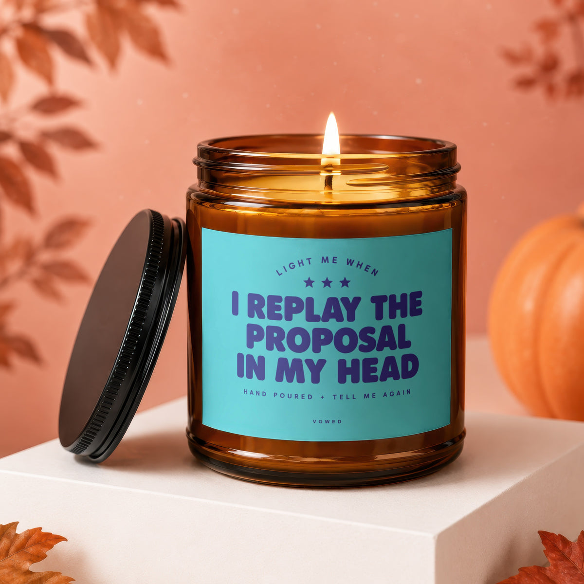 Candle with text "I replay the proposal in my head" on a teal label.